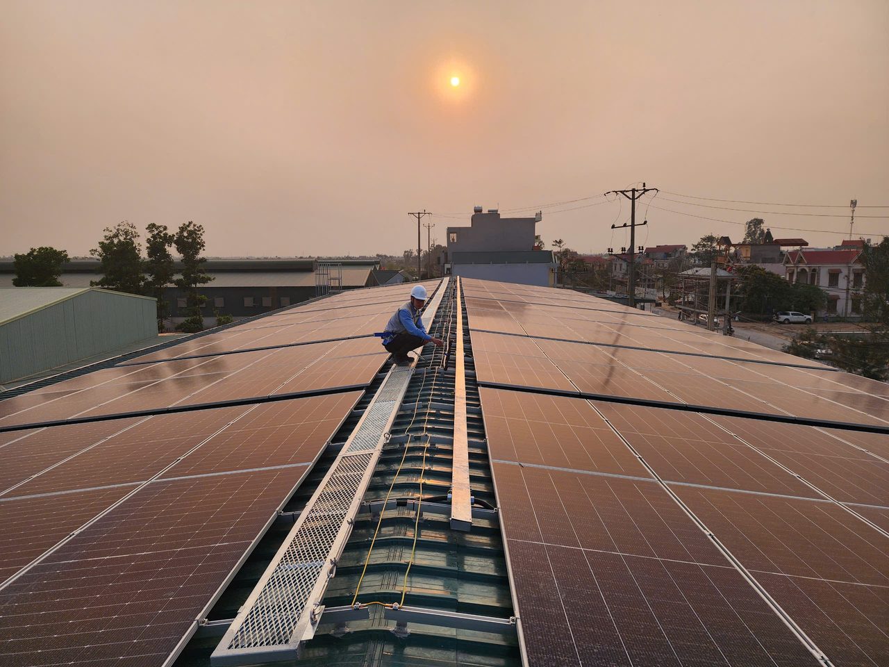 Kỹ sư IGREEN SOLAR kiểm tra hệ thống điện mặt trời áp mái nhà máy lúc hoàng hôn