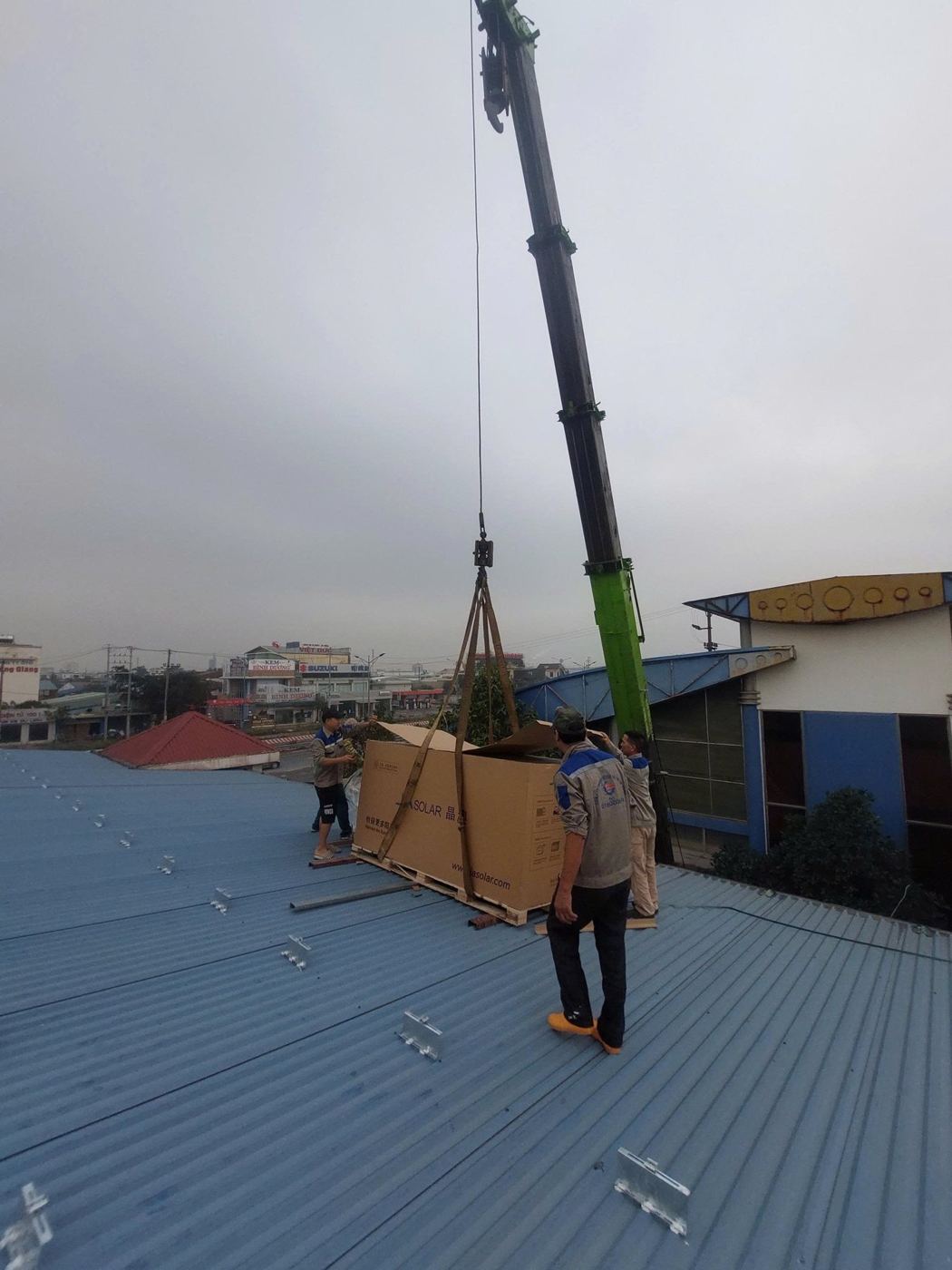 Cẩu vật tư lên mái — công trình Công ty TNHH Bạch Đằng, 100 kWp (iGreen thi công 03/2025).